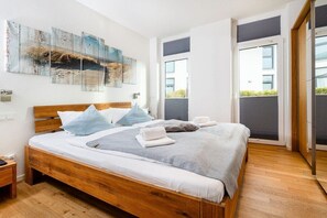 Une chambre moderne avec un lit en bois, une grande fenêtre et une vue sur la ville.