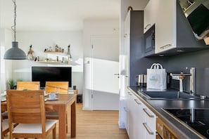 Eine moderne Küche mit Mikrowelle, Herd und einer Tasche auf der Arbeitsfläche.