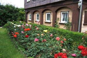 A building with a garden featuring a variety of roses. - Holiday apartment with 2 bedrooms (Waltersdorf)