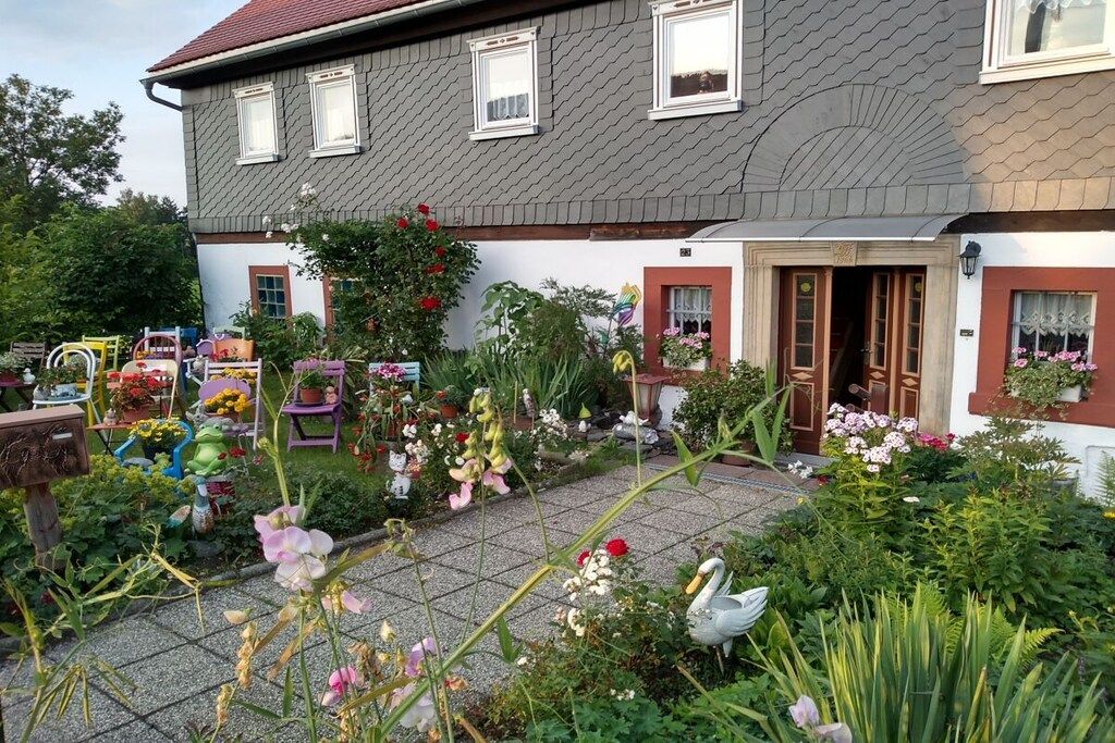 Ett tvåvåningshus med en trädgård framför.