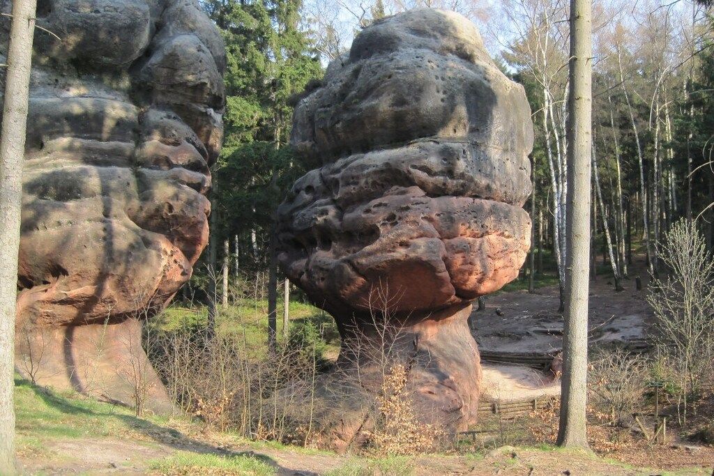 Una formació rocosa natural amb un camí ben marcat que travessa una zona boscosa.