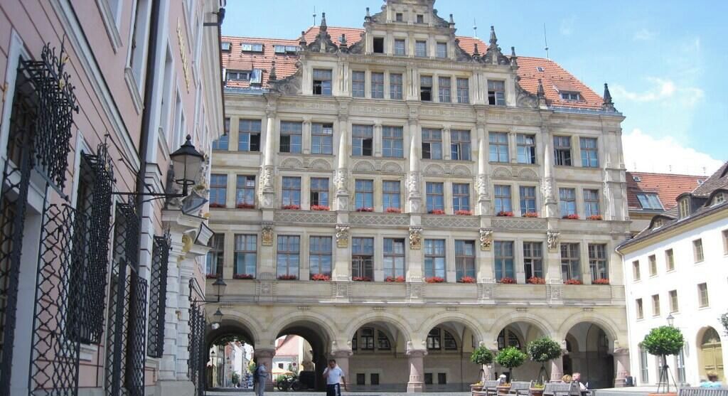 A historic building with multiple floors, large windows, and a central entrance with arches.