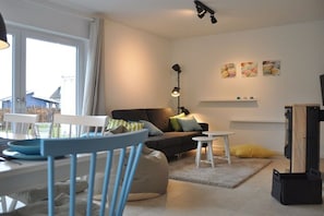 A modern living room with a sofa, chairs, a coffee table, and a lamp. - Holiday home with 3 bedrooms (Breege\/ Juliusruh OT Breege)