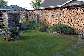 Ein Garten mit einer Steinmauer, einem kleinen Tisch und verschiedenen Pflanzen.