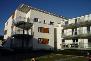 A modern multi-story residential building with balconies, a flat roof, and a clear sky. - Holiday apartment with 1 bedroom (Breege\/Juliusruh OT Juliusruh)