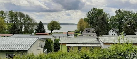 A residential area with houses, a body of water, and a cloudy sky.