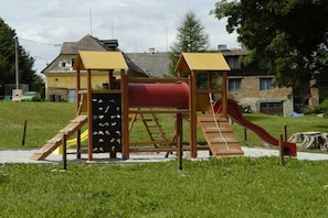 A playground with a slide and climbing structures.