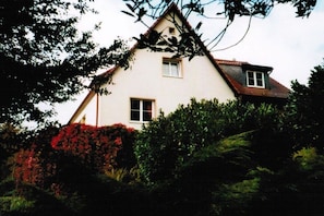 A two-story house with a gabled roof, a front door, and a window. - Holiday apartment in Struppen with barbecue (Struppen)