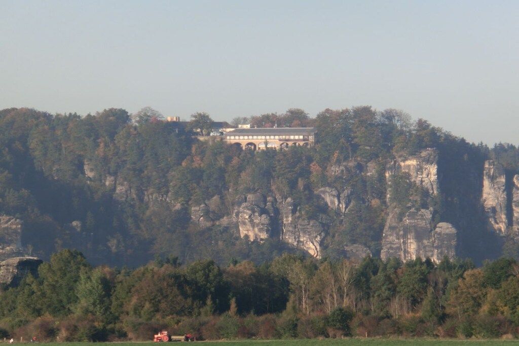 Un bâtiment situé sur une falaise, offrant une vue sur le paysage environnant.