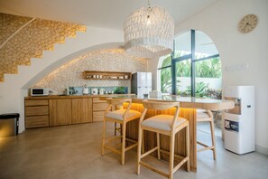 Eine moderne Küche mit einer Steinwand, Holzbarhocker und einem großen Fenster.