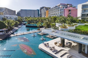 A hotel with a swimming pool, outdoor seating, and modern architecture.