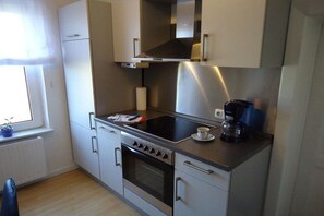 A compact kitchen with a stove, oven, and a coffee maker on the countertop. - Holiday home in Hammah with swimming pool (Hammah)