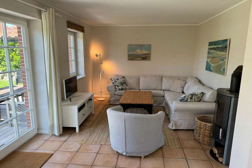 A cozy living room with a sofa, a television, a coffee table, and a fireplace.