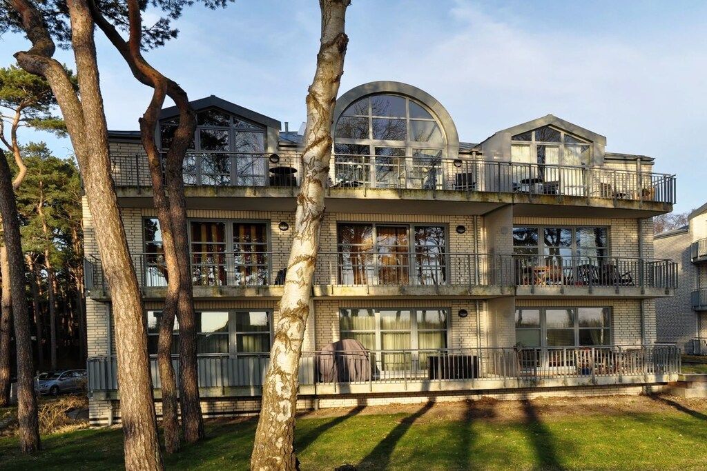 Un edificio de varios pisos con balcones, ventanas amplias y un tragaluz circular.