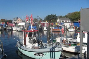 A marina with various boats docked, including a prominent boat with 'TIM 100' on its side. - Holiday home with 4 bedrooms (Timmendorfer Strand)