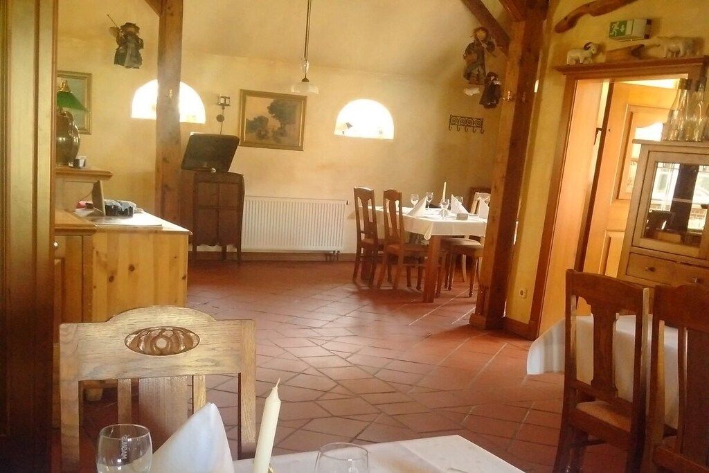 A dining area with wooden furniture, a table set for two, and a radiator on the wall.