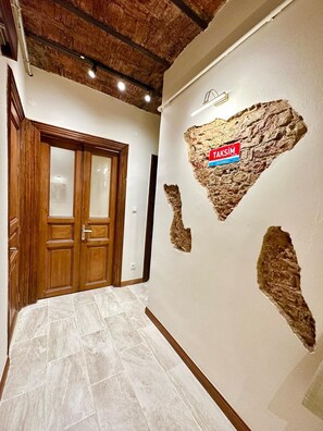 A hallway with a wooden door, a tiled floor, and a wall with a heart-shaped design and a sign indicating 'Taksim Istanbul'. - Historic 2BRApt. with 2 Bathrooms, Turkish Bath & 3AC @Taksim (Istanbul)