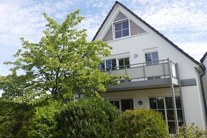 Ein zweistöckiges Gebäude mit einem Balkon im oberen Stockwerk.