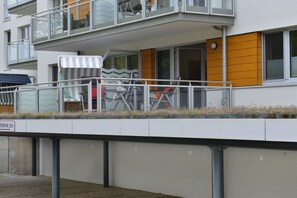 Un immeuble résidentiel doté d’un balcon, de mobilier d’extérieur et d’une petite table.