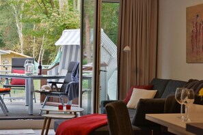 Un salon moderne avec un canapé, une table à manger et une vue sur un bâtiment traditionnel situé à l’extérieur.