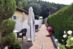 A patio area with outdoor seating, a pathway, and a hedge. - House by the Forest Apartment 3 (Seebad Ahlbeck)