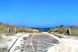 A paved pathway leading to a beach with a clear sky. - House by the Forest Apartment 3 (Seebad Ahlbeck)