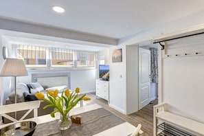 A modern bedroom with a bed, bedside table, lamp, and a view of the sea through a window. - Richard House Apt. 3 (Seebad Ahlbeck)