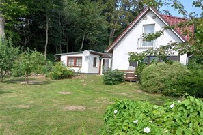 A two-story house with a red roof, surrounded by a well-maintained garden and trees. - in the Recknitz valley (Ahrenshagen- Daskow)