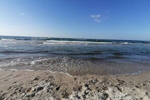 A beach with waves approaching the shore, sandy beach, and a clear sky. - in the Recknitz valley (Ahrenshagen- Daskow)