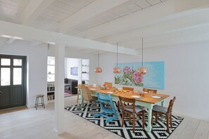 A dining area with a wooden table, chairs, and a black and white patterned rug. - Holiday home in Barth with swimming pool (Barth)