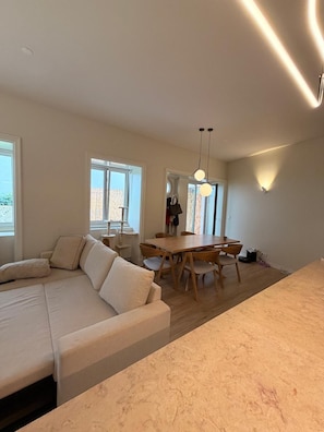 A modern interior with a sectional sofa, dining table, and chairs. - One-bedroom apartment with a large terrace near Avenida da Liberdade (Lisboa)