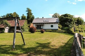 A house with a sloped roof, a small front porch, and a well-maintained lawn.