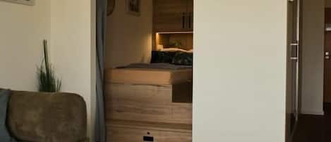 A modern interior with a sofa, a small table with a container, and a wooden cabinet in the background.