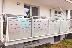 A balcony with frosted glass panels and a metal railing. - Holiday apartment with 1 bedroom (Breege\/ Juliusruh OT Juliusruh)