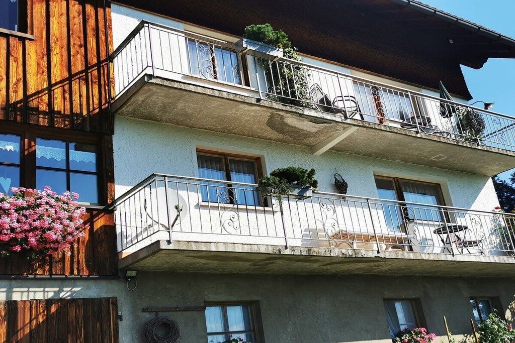 A multi-story building with balconies, windows, and outdoor seating.