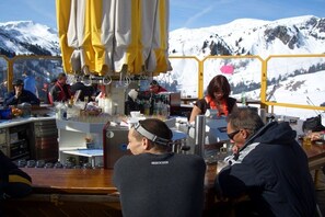 A bar area with a view of snow-covered mountains. - Holiday home in Doren with swimming pool (Doren)