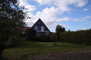 A house with a triangular roof, a balcony, and a well-maintained lawn. - Holiday home in Jabel with swimming pool (Jabel)