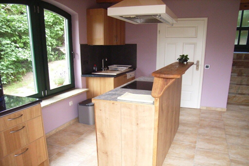 A compact kitchen with wooden cabinets, a window, and a built-in stove.