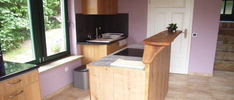 A compact kitchen with wooden cabinets, a window, and a built-in stove.