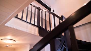 A wooden staircase with a handrail leading to an upper floor.