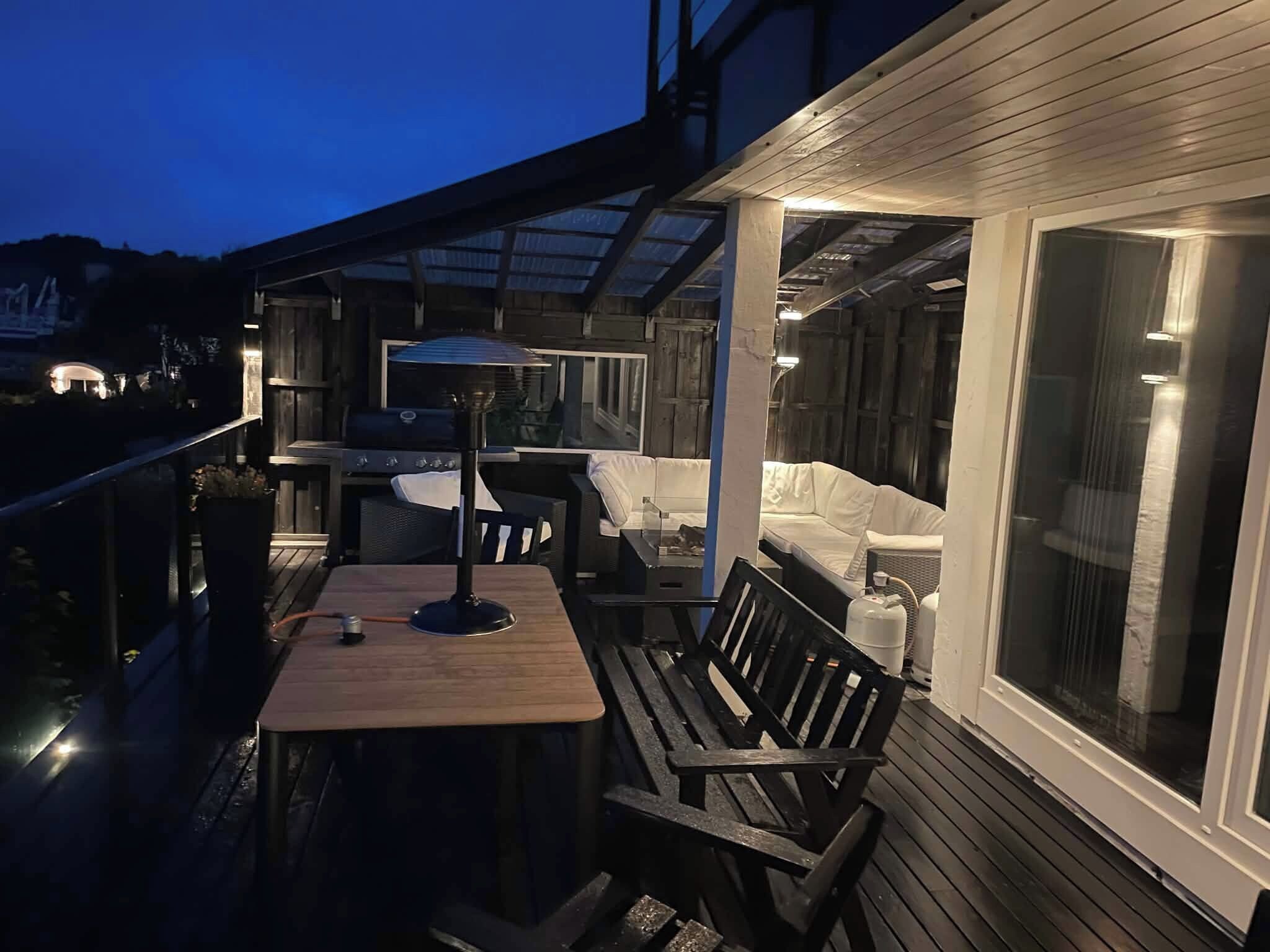 An outdoor patio with a table, chairs, and a grill.