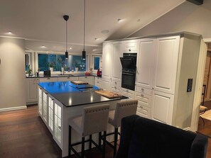 A modern kitchen with a central island, white cabinetry, and a black refrigerator.