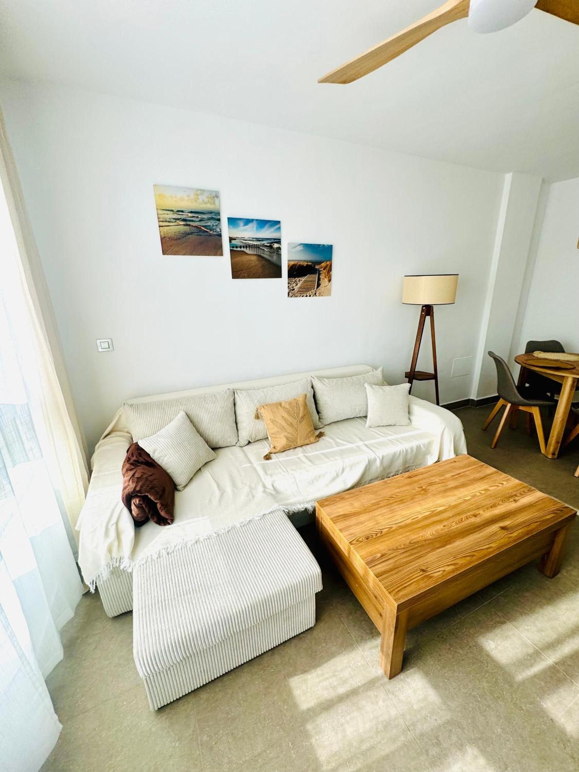 Una sala moderna con un sofá seccional, una mesa de centro de madera y una lámpara de pie.