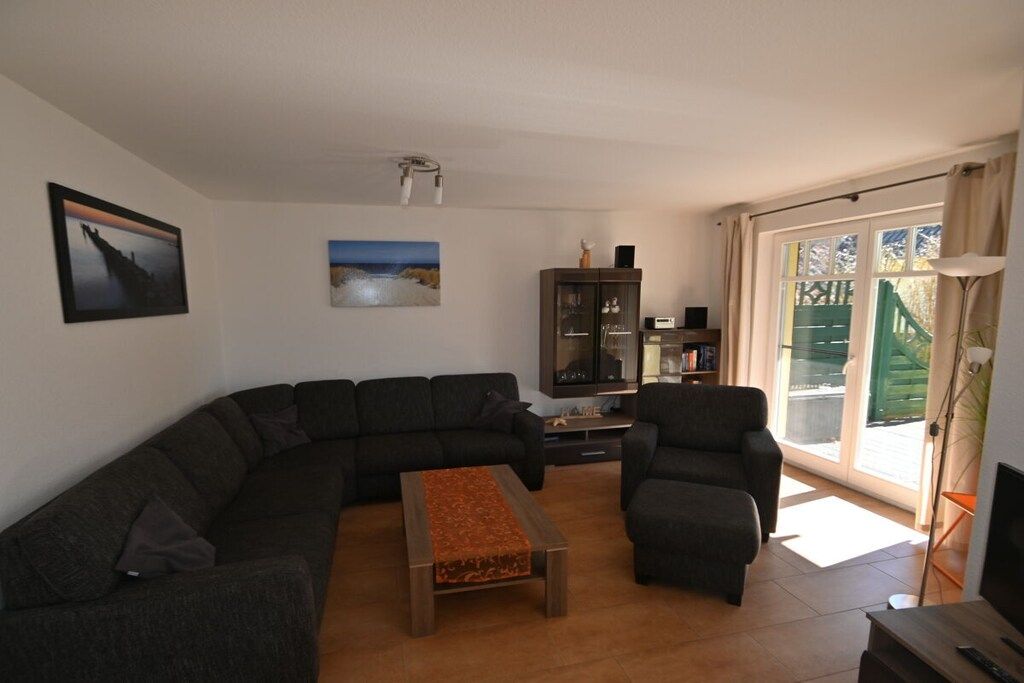 A living room with a sectional sofa, a coffee table, a cabinet, and a television.
