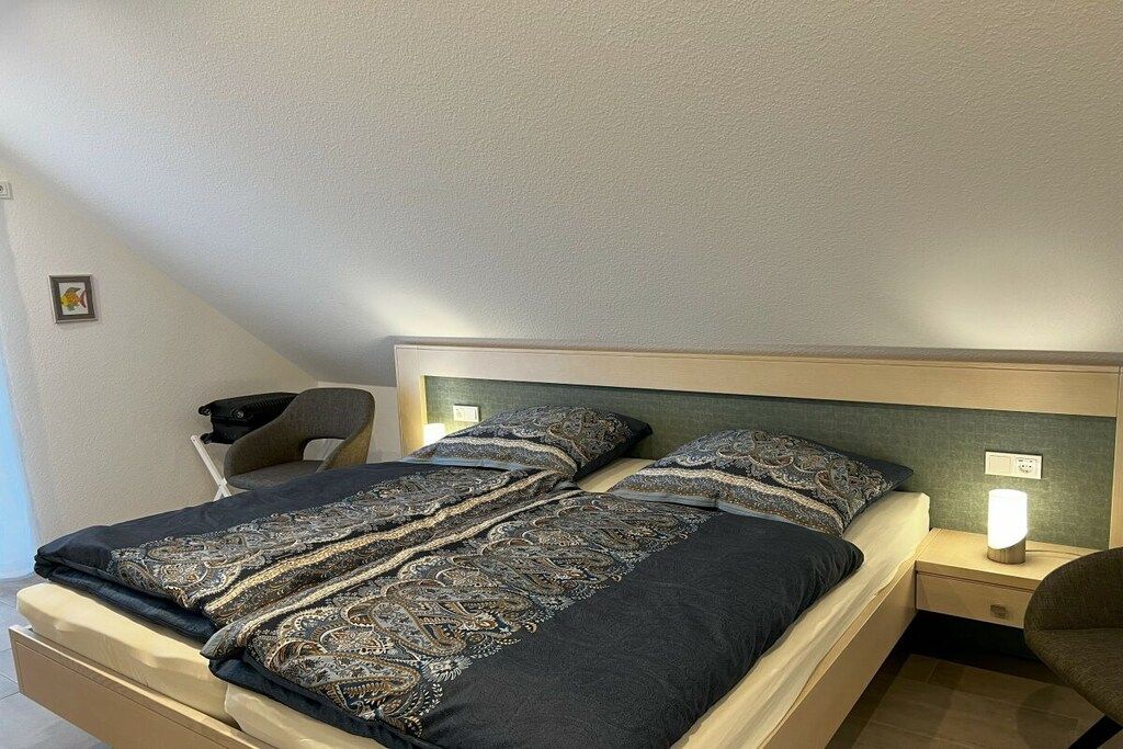 Une chambre à coucher avec un lit, des tables de chevet et une chaise.