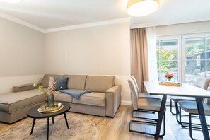 Ein modernes Wohnzimmer mit einer Couch, einem Couchtisch und einem Essbereich mit Stühlen und einem Tisch.
