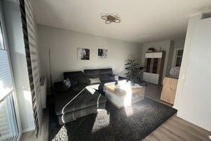 Ein modernes Wohnzimmer mit einer Couch, einem Couchtisch und Kunstwerken an der Wand.