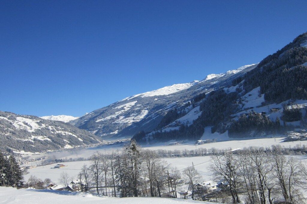 A mountainous landscape with snow-covered peaks and a valley.
