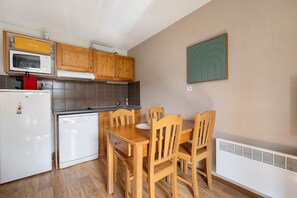 A compact kitchen with wooden cabinets, a microwave, a red coffee machine, and a white dishwasher. - Apartment 'Albiez 4 to 6 guests' with mountain view and balcony (Albiez-Montrond)