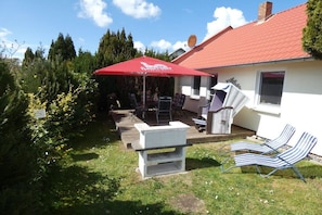 A house with a red roof, a patio with outdoor furniture, and a satellite dish. - Holiday apartment in Glowe with swimming pool (Glowe)